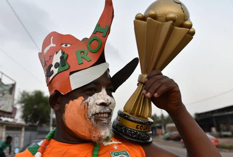 La tenuta per assistere alla partita prevede modellino in miniatura della Coppa d&#39;Africa e copricapo patriottico a tema. Afp